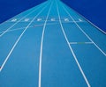 Olympic track lanes with white stripes and start and finish numbers, empty Blue background for copy space, concept of physical