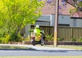 Postie bike Australian postman riding a motorbike during a working time. Royalty Free Stock Photo