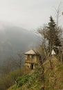 Terrible view of a ruined house next to a roadside hedge with broken doors and windows in the middle of a foggy forest,Iran