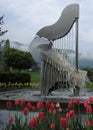 The amazing Harp Fountain with water strings surrounded by beautiful tulips in Ossiach