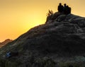 OM BEACH,GOKARNA,KARNATAKA/INDIA-FEBUARY 2, 2018:Young men sit on a hill of rocks,watching the sunset. Royalty Free Stock Photo