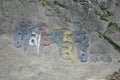 Om Mani Padme Hum Buddhist mantra written Tibetan script on rock in Rewalsar lake Tso Pema, Himachal Pradesh, India Royalty Free Stock Photo