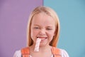 Om nom nom. A cute little girl eating candy against a colorful background. Royalty Free Stock Photo