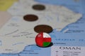 Oman flag on the coin of Rial Omani money put on the map. Concept of finance or travel
