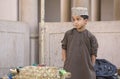 Omani boy in traditional clothing at a market