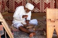 Omani carpenter or wood carver working on a quran book rest called rehal in Nizwa fort Royalty Free Stock Photo