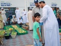 Omani kid buying fresh fruits in fruit bid market