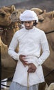 Omani man with his camels in a countryside Royalty Free Stock Photo