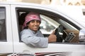 omani man with a traditional headscarf posing from his car window