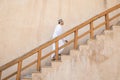 Omani man walking up the stairs in Nizwa fort