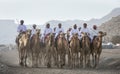 Omani men riding camels in a countryside of Oman Royalty Free Stock Photo