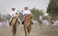 Omani men riding camels on a dusty countryside road Royalty Free Stock Photo