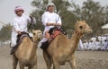 Omani men riding camels on a dusty countryside road Royalty Free Stock Photo