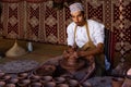 Omani potter working on his turntable, forming a bowl from clay with his hands in Nizwa fort