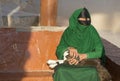 Omani woman in a market with a baby goat