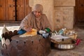 Omani woman in traditional dress preparing a crispy crepe in Nizwa fort