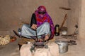 Omani woman in traditional dress roasting coffee beans at Bait al Safah museum, Al Hamra