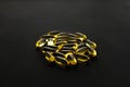 Omega 3 capsules on black dark background. Dietary supplements. Fish oil in pills. Health support and treatment. Biologically Royalty Free Stock Photo