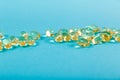 Omega 3 capsules on blue background. Some fish oil capsules, close up