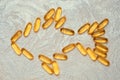 Omega3 capsules in fish shape silhouette on a cement background. Royalty Free Stock Photo