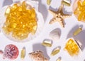 Omega 3 capsules and seashells with long shadows. Top view photo of supplement food with oil of nordic fish. Vitamins and tablets