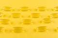 Golden omega capsules on yellow background closeup