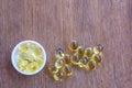 Omega 3 fish liver oil capsules in wooden background.