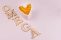 Omega-3 fish oil capsules are laid out with a heart on a white backgro Royalty Free Stock Photo