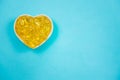 Omega 3 fish oil capsules spilling out of a bottle on a blue background. selective focus Royalty Free Stock Photo