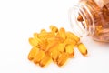 Omega 3 fish oil capsules spilling out of a bottle on a white background. Royalty Free Stock Photo