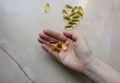 Omega 3 pills in woman`s hand on marble background. Healthy diet supplements. Fish oils for vegans food