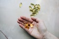 Omega 3 pills in woman`s hand on marble background. Healthy diet supplements. Fish oils for vegans food Royalty Free Stock Photo