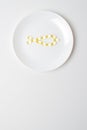 Omega-3 polyunsaturated fatty acids on a plate. Fish oil softgels on a white plate in a shape of a fish. Meal replacement. Casual