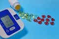 Omega-3 polyunsaturated fatty acids and red decorative and cardiac tonometer on a blue background. Prevention and