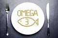 Omega 3 from salmon oil capsules on white plate with fish shape Royalty Free Stock Photo