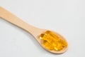 Omega 3 vitamins on a wooden spoon on a white background Royalty Free Stock Photo