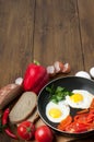 Omelet with bread, tomatoes and bell pepper in skillet pan.