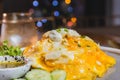 Omelet, fried beaten eggs on a white plate. Placed on a wooden table ready to eat.