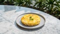 Omelet with herbs on a plate on white marble table.