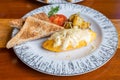 Omelet with potato, tomatoes parsley and feta cheese and bread in white plate on wooden table Royalty Free Stock Photo