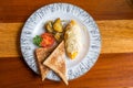 Omelet with potato, tomatoes parsley and feta cheese and bread in white plate on wooden table Royalty Free Stock Photo