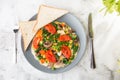 Omelet with vagetable, tomatoes, mushrooms,green beans, pease, corn, sourdough toast on white marble background. Homemade