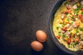 Omelette in frying pan on dark background, top view. garlic and