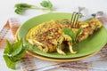 Omelette with goutweed on green plate
