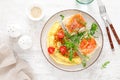 Omelette or omelet, fresh arugula and tomato salad and toasts with butter and salted salmon. Breakfast. Top view