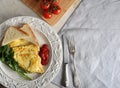 Omelette on a plate, parsley, tomatoes, toast, ketchup