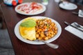 Omelette, roasted potatoes and avocado slices on a white plate