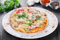 Omelette with slices ham, mushrooms, greens, cheese and tomato on dark wooden background. . Royalty Free Stock Photo