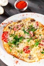 Omelette with slices ham, mushrooms, greens, cheese and tomato on dark wooden background. Royalty Free Stock Photo