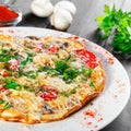 Omelette with slices ham, mushrooms, greens, cheese and tomato on dark wooden background. Royalty Free Stock Photo